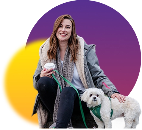 Woman seated with a small white dog, holding a to-go cup