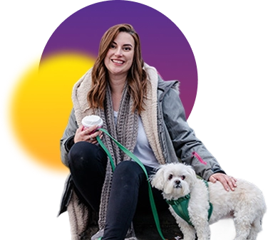 Woman seated with a small white dog, holding a to-go cup